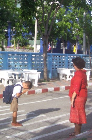 Buddhist child is greeting his teacher in Thailand