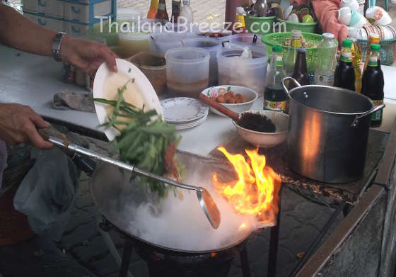 Cooking water spinach on very high heat in Thailand.